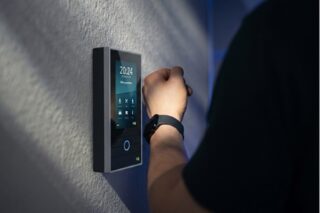 Mann hält seine Uhr an ein INTUS-Terminal