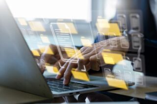 Hände tippen auf einem Laptop, überlagert von schwebenden Symbolen für Ordner und Dokumente – Konzept für Dateiverwaltung, Cloud-Speicher und digitales Dokumentenmanagement.